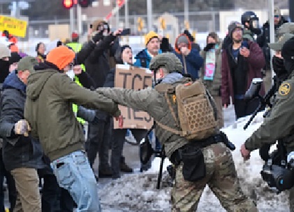 ICE enforcement officer confronting a protester during a demonstration in winter conditions